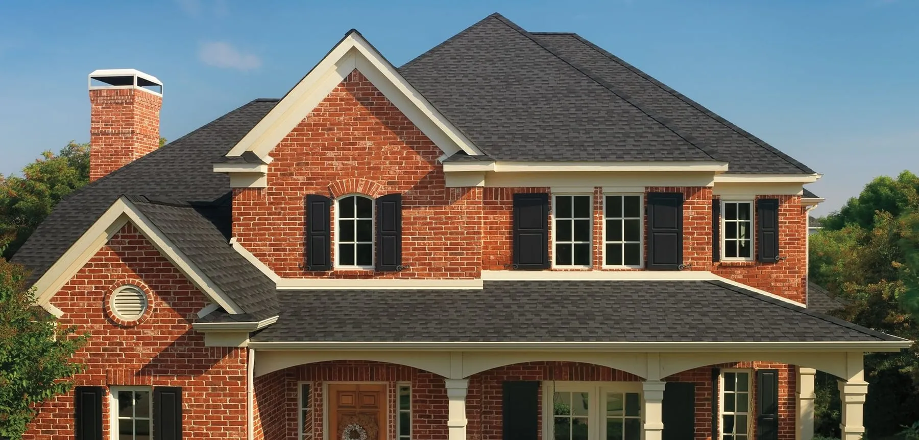 A two-storey brick home in North Texas with a completed shingle roof